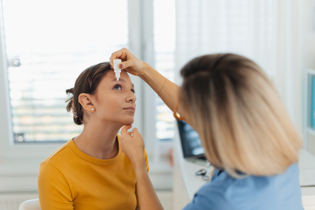 Doctor treating patient with eye drops
